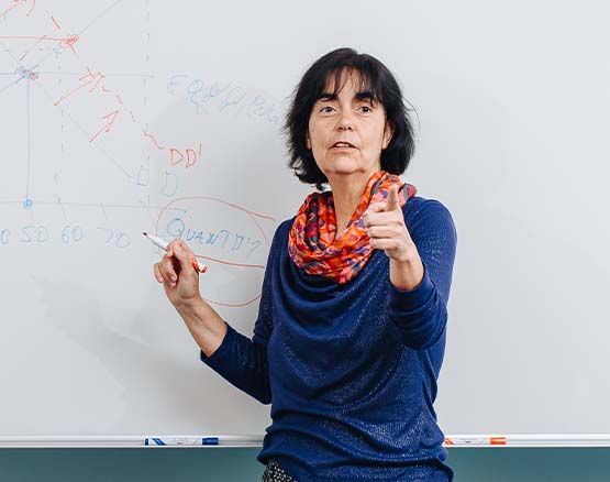 MBA teacher points to a student off camera as she draws a supply and demand curve