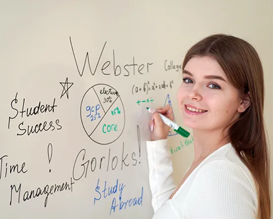 Female student standing in front of a green screen.