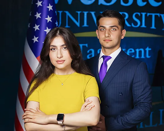 Two Tashkent students pose in front of U.S. flag.